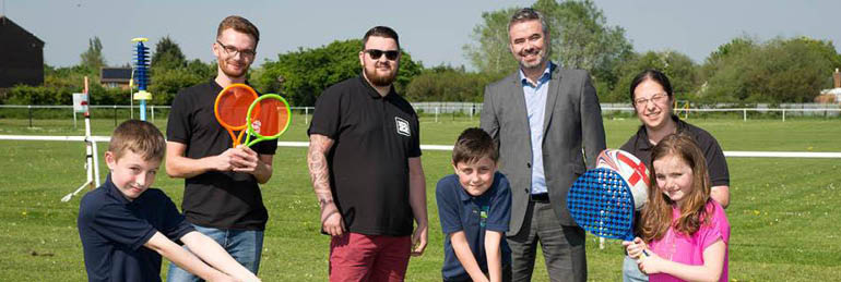 David McKendrick with kids and helpers at a sports field